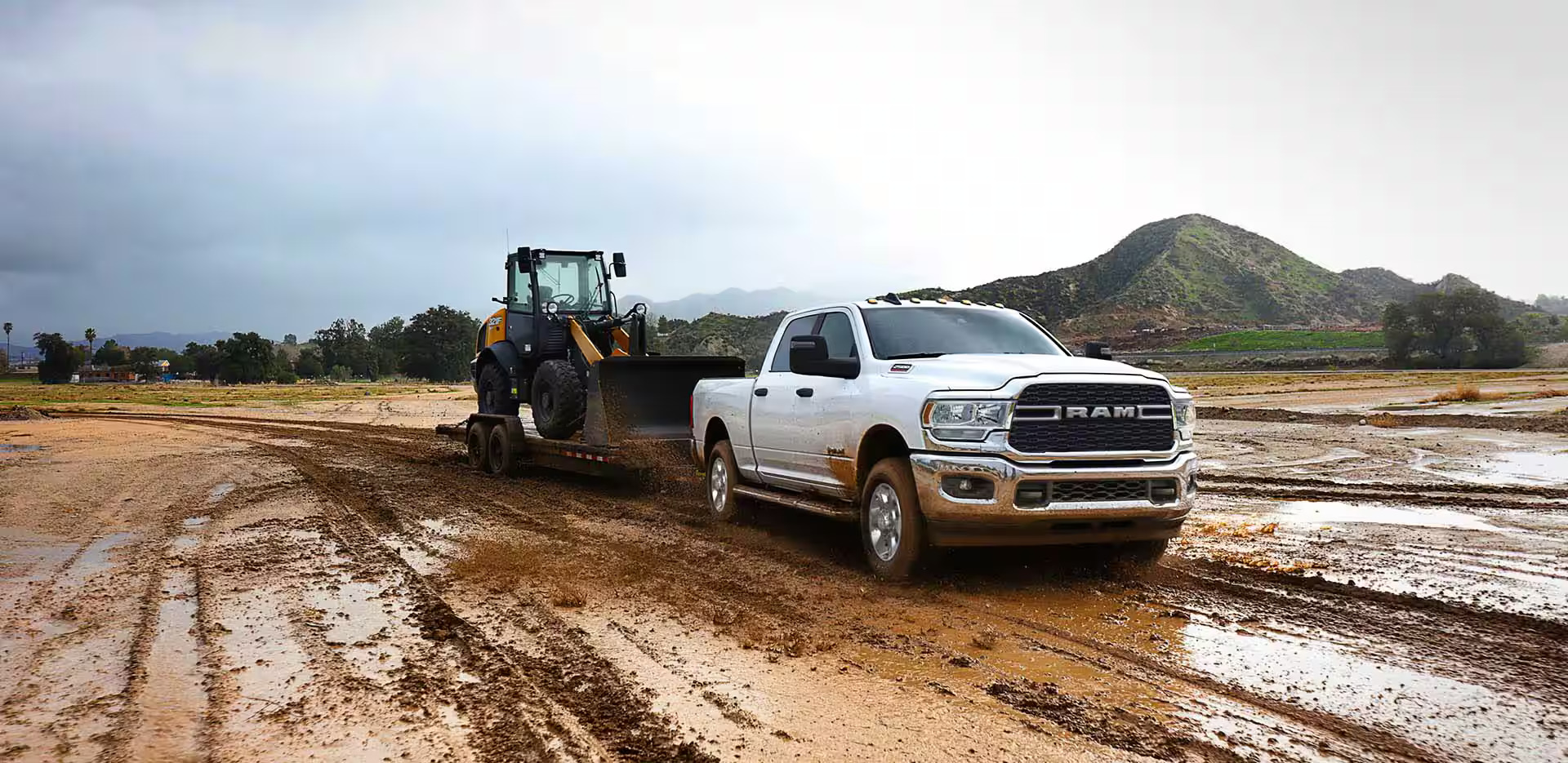 A white ram 2500 pulling a bulldozer.