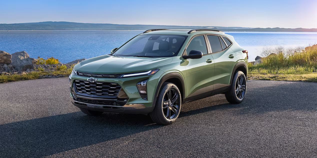 a green SUV parked next to a lake