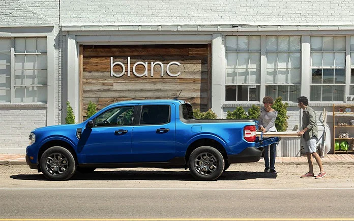 image of two people loading bed of blue ford maverick