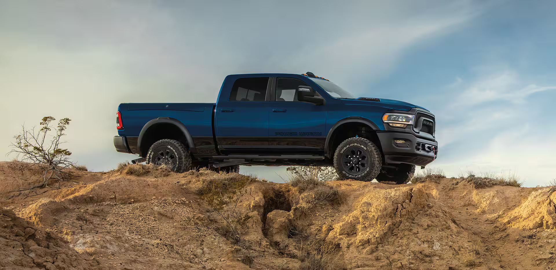 A blue ram 2500 parked in the desert.