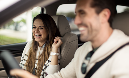 man and woman smiling inside of their Buick