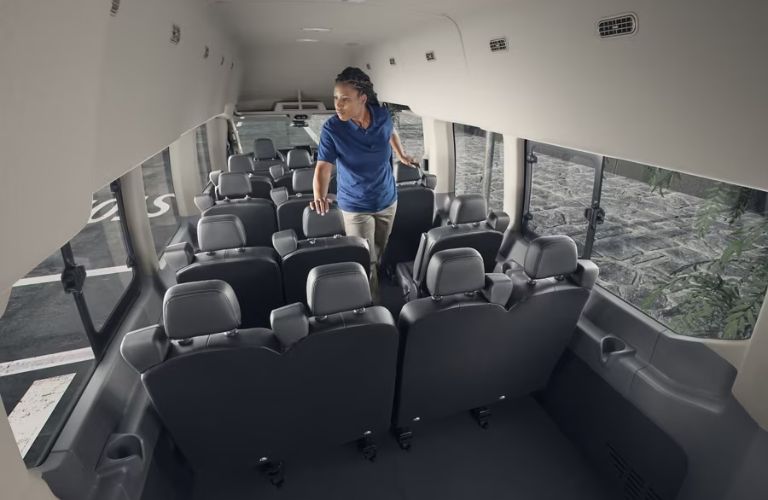 Woman Standing by Rear Seats in 2024 Ford Transit Passenger Van