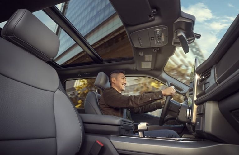 Man Driving 2023 Ford F-150 Lightning with Panoramic Moonroof 