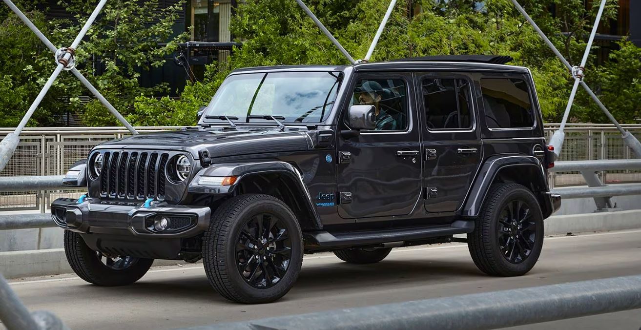 black 2023 Jeep Wrangler PHEV 4xe driving on a bridge