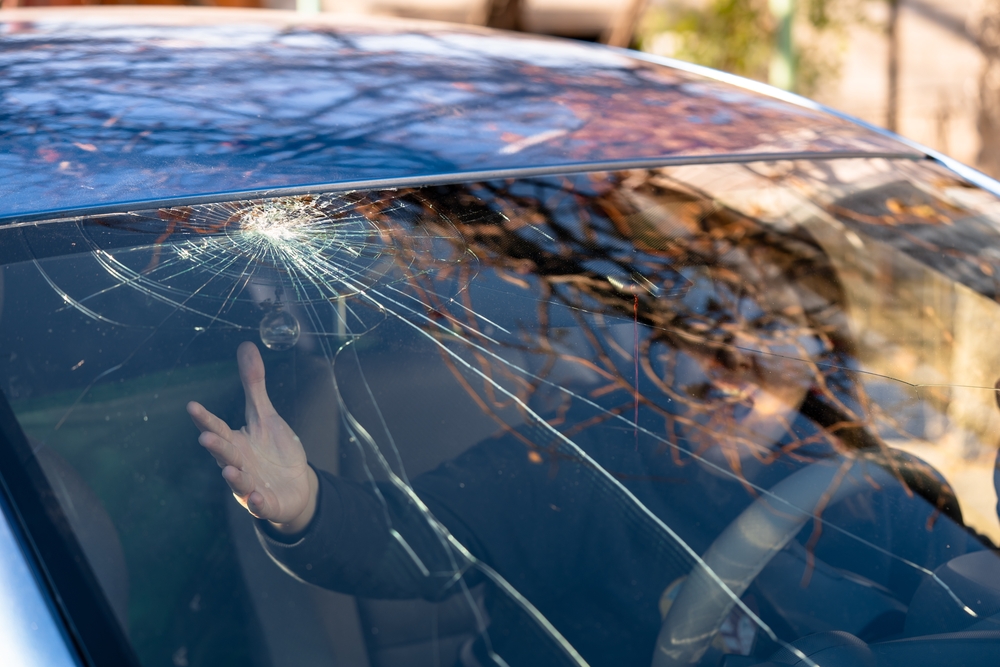 woman inside of vehicle concerned about her cracked windshield