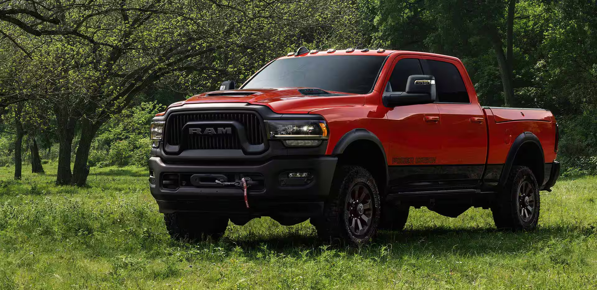 A red ram 2500 parked in the woods.