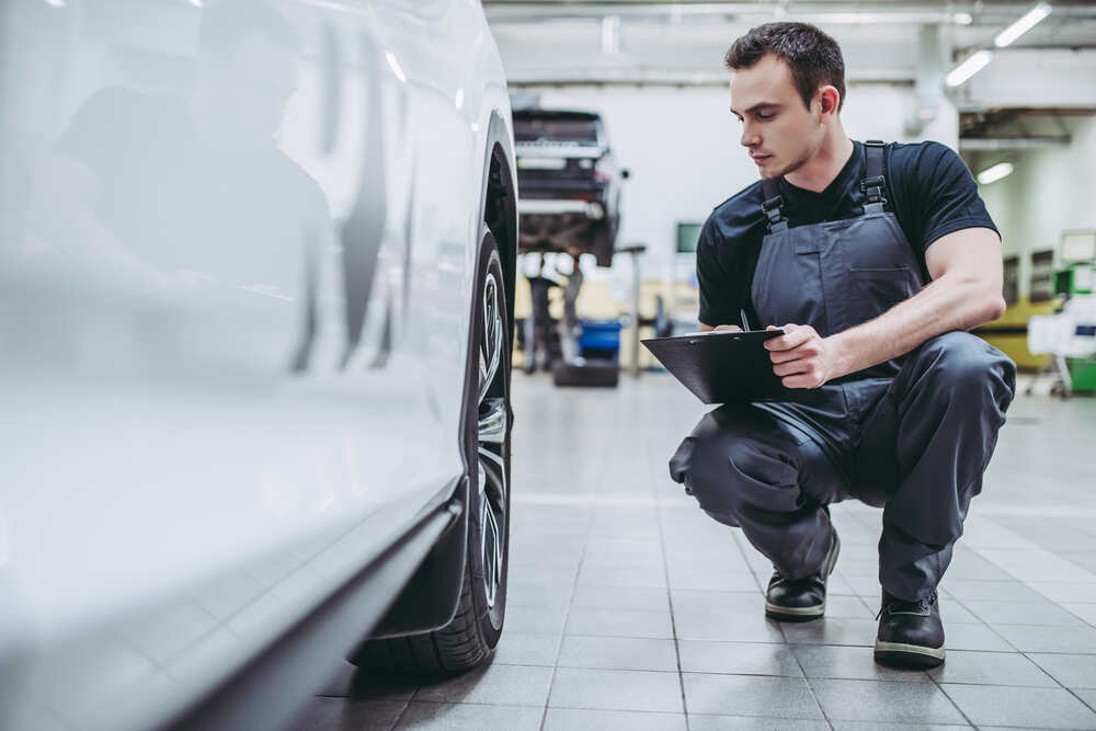 Auto mechanic inspecting car.