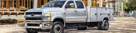 a gray Chevrolet Silverado 4500 commercial truck providing dedicated service to a construction site that currently only has the foundation up.