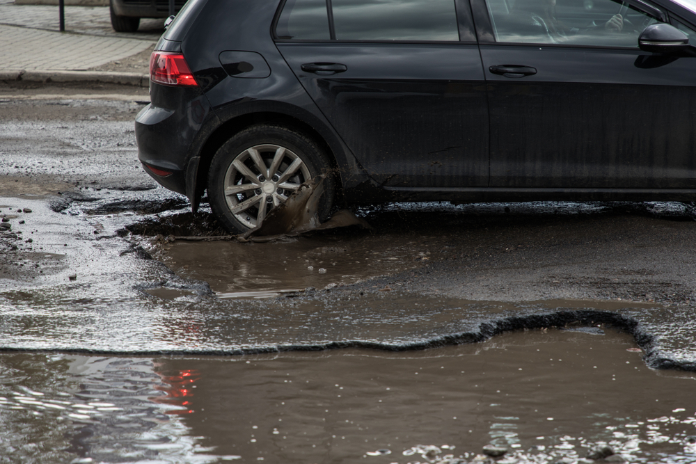 wheel of a vehicle driving through a pothole