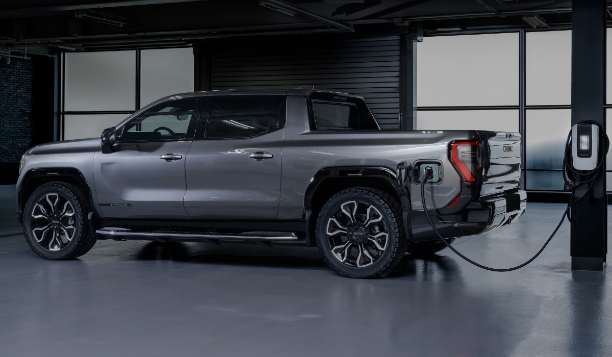 2024 GMC Sierra EV Denali Edition 1 Exterior Driver Side Rear Profile while Charging