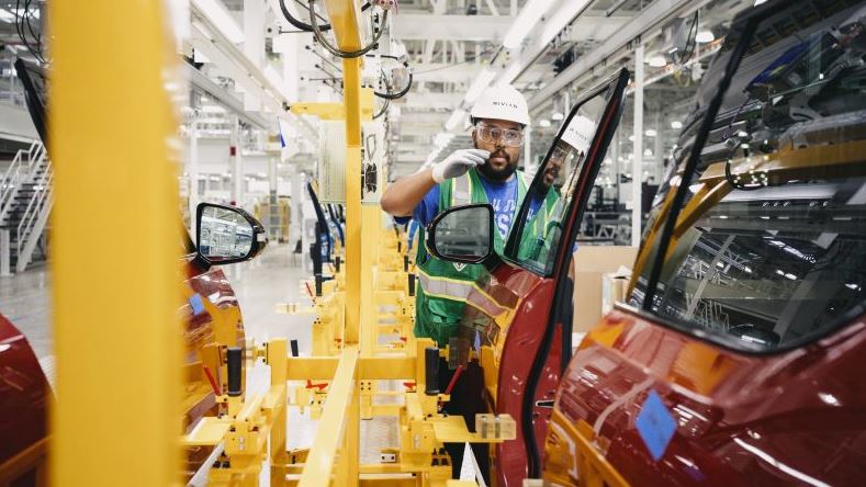 technician in a hard hat prepares to work on a red mobility van door