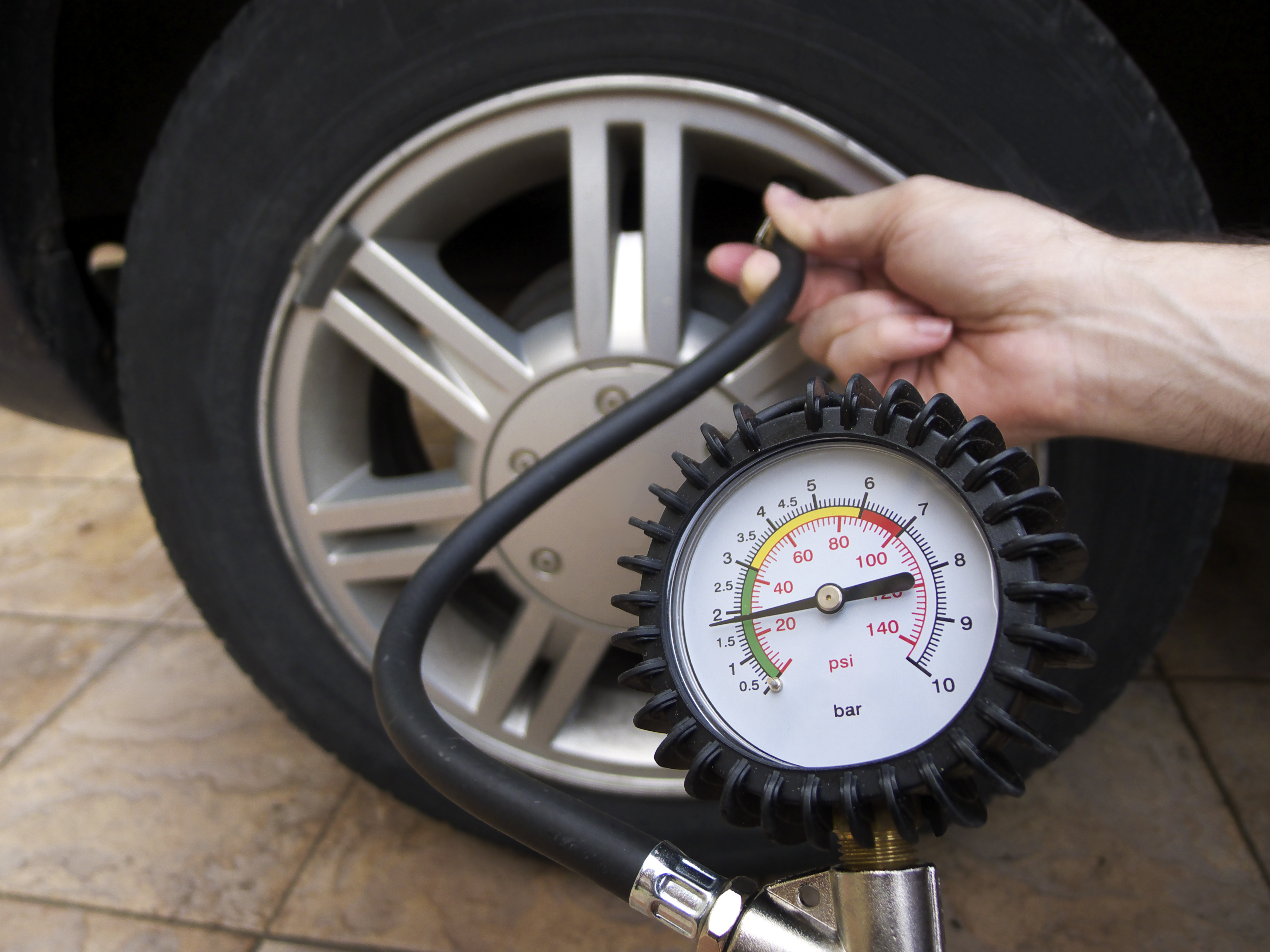 tire pressure gauge checking psi of vehicle's tire