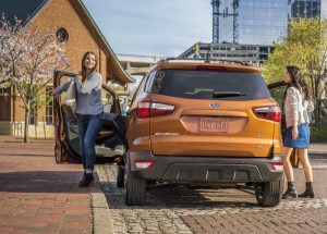 rear view of an orange 2019 Ford EcoSport with two women getting out of it