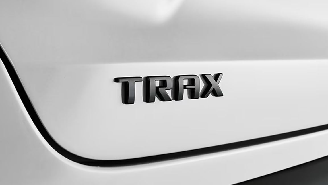 black Trax nameplate displayed on a Summit White 2024 Chevy Trax