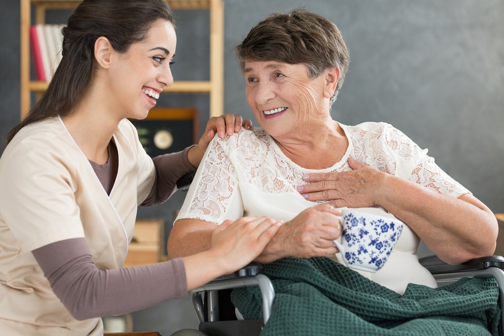 Nurse helping senior woman in wheelchair