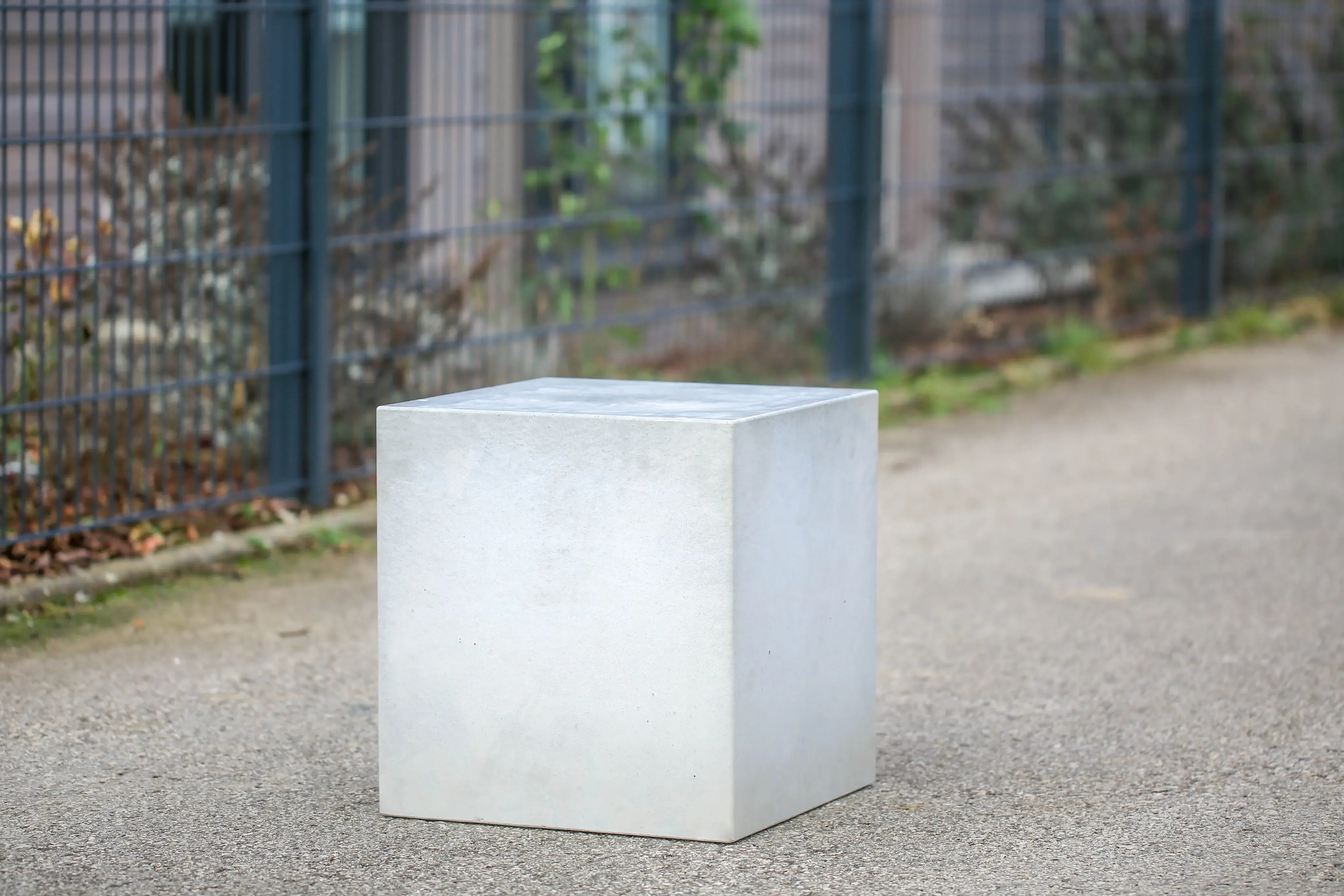 Massiver Poller aus Sichtbeton steht auf öffentlichem Weg zur Durchfahrtsbeschränkung