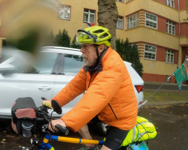 Gerd Steiner en route to the Brandenburg Gate. Volker Mai of Respect Cyclists group will recieve the banner, originally from COP30 in Belem, Brazil, and hand it to the next rider scheduled to head to Dresden