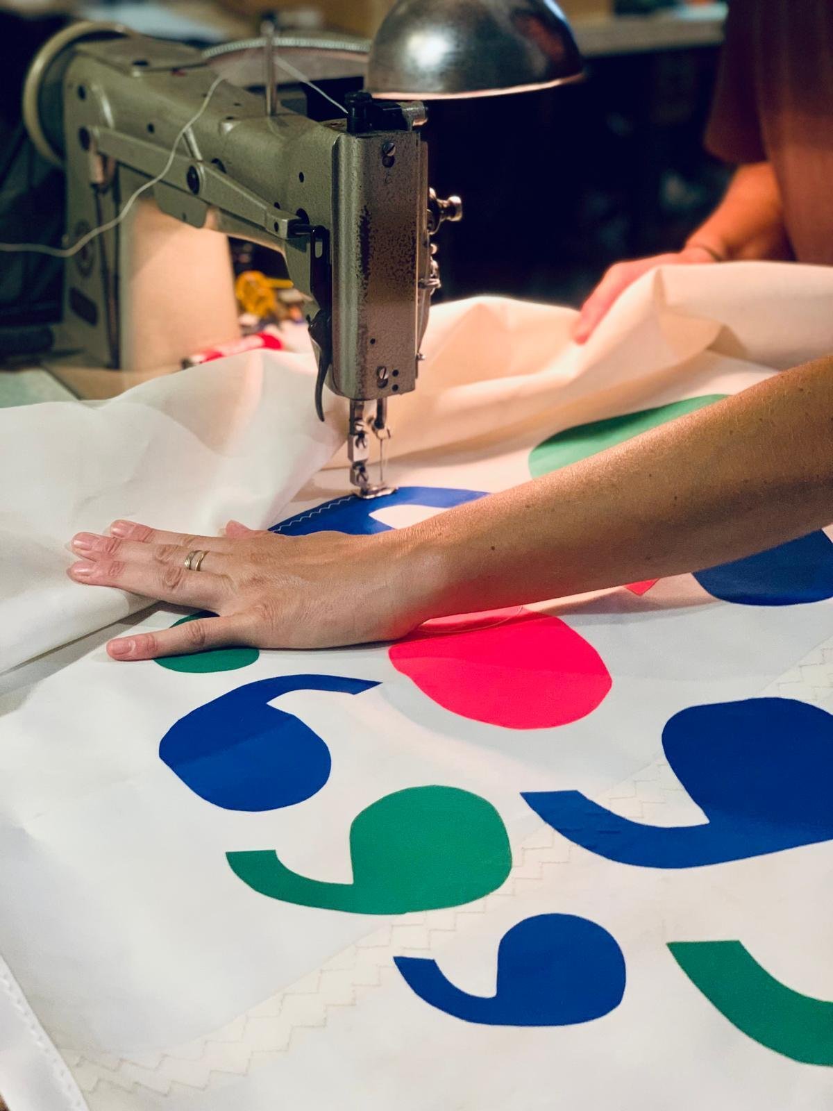 Hand-embroidering seven of The Earth Prize Winner flags
