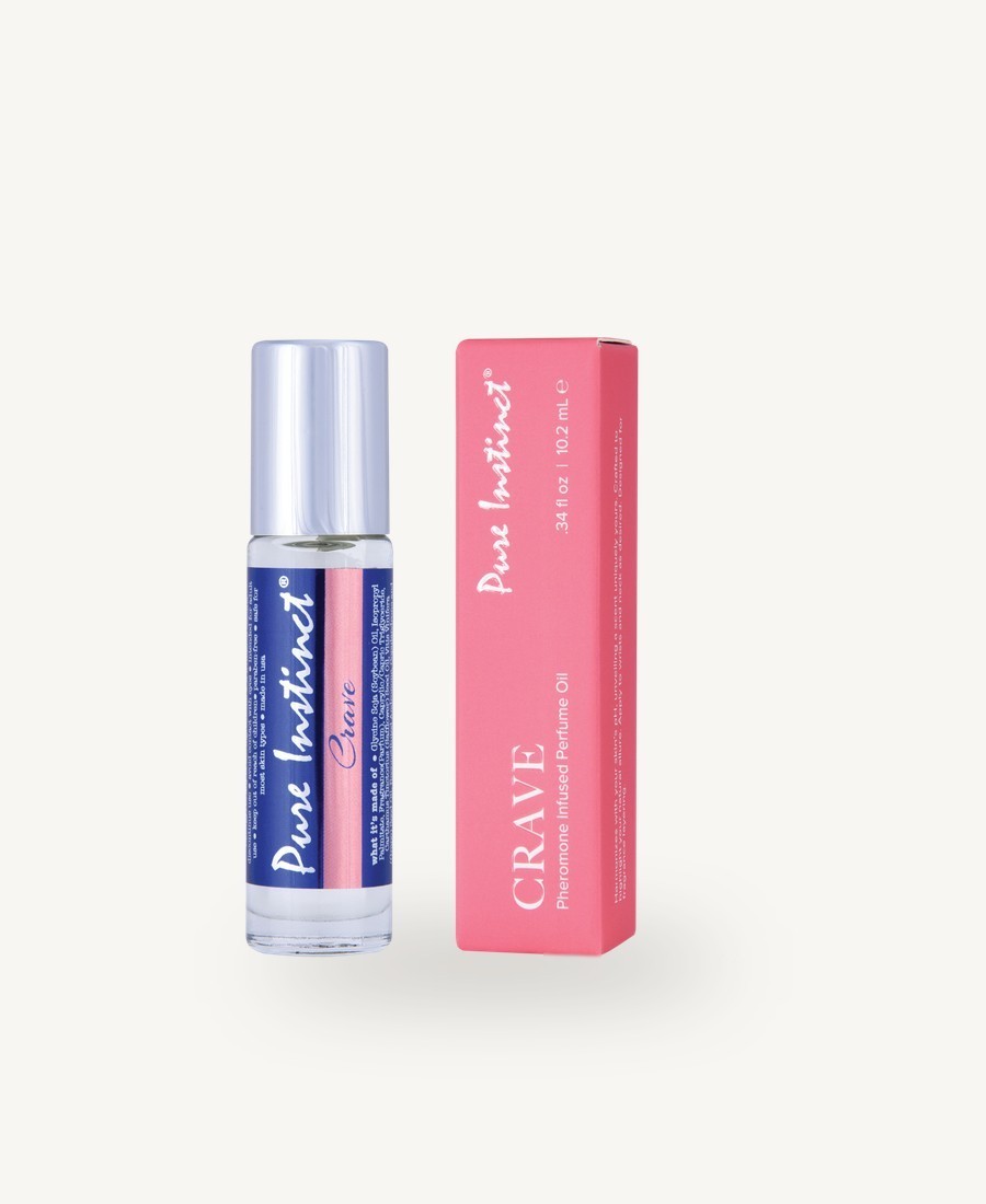 A clear Pure Instinct CRAVE roll-on bottle with a silver cap next to its pink CRAVE box