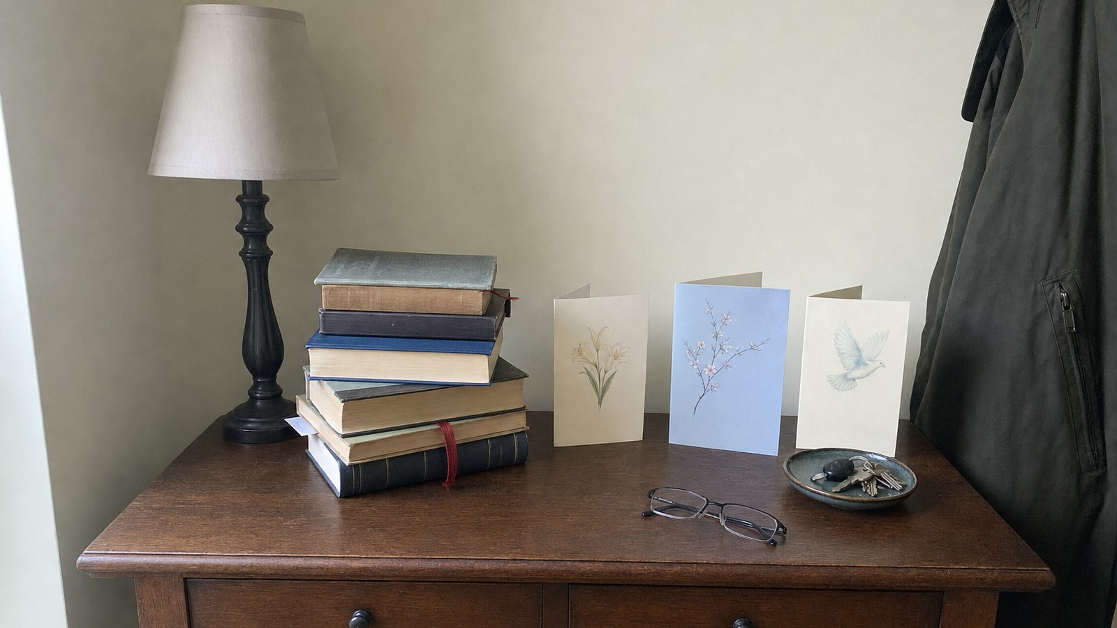 A hall table with a stack of devotional books and a few sympathy cards
