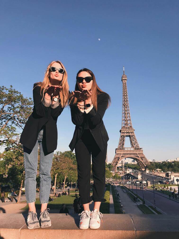 girls taking a selfie in front of paris eiffel tower