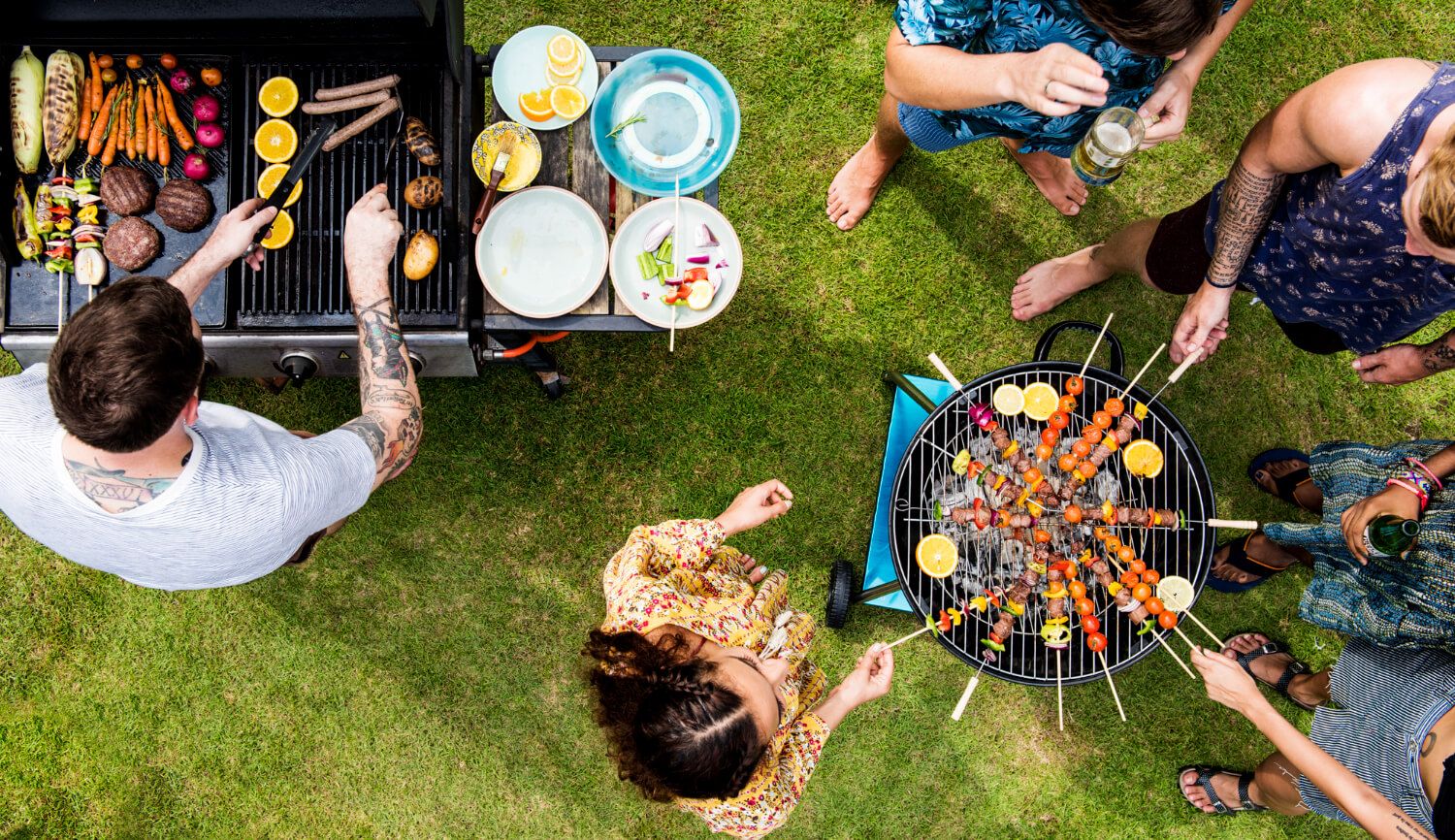 Backyard BBQ setup with games and grilling