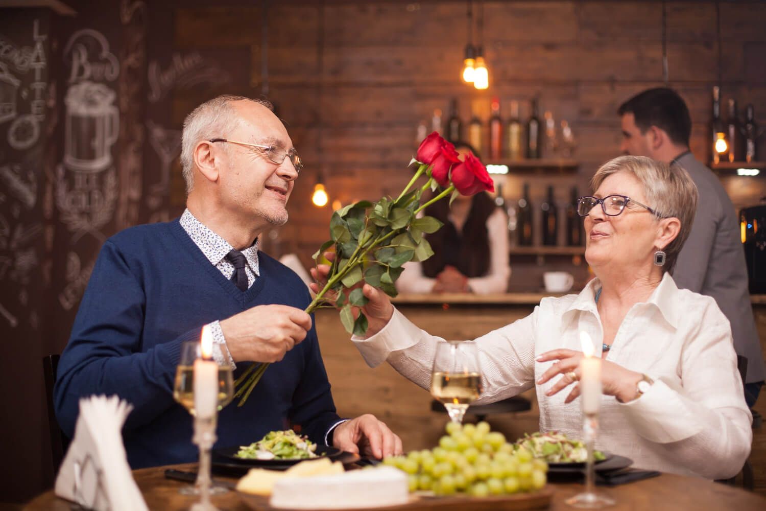 Elderly couple celebrating anniversary with a candlelight dinner.jpg