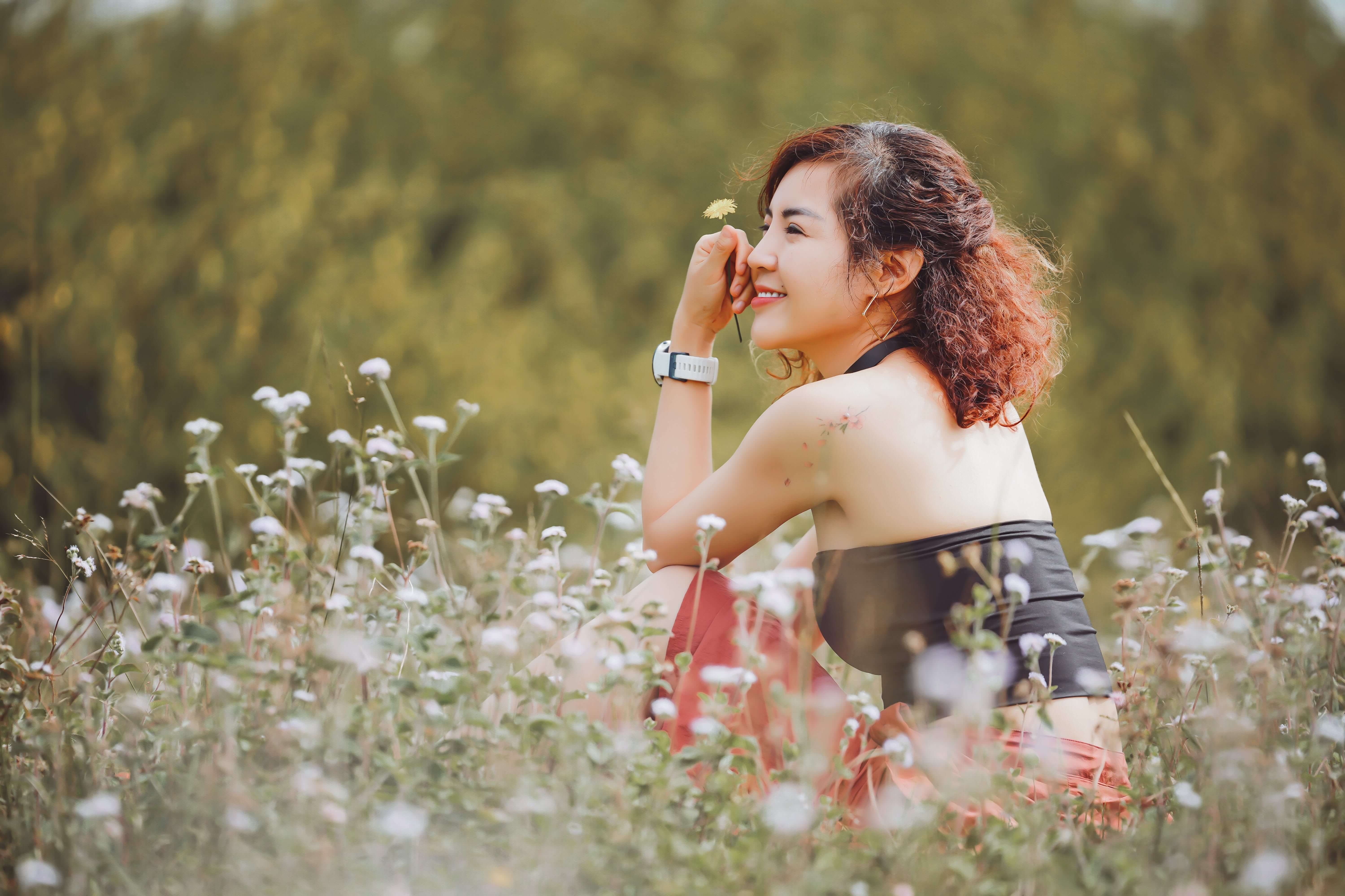 Woman sitting in a flower field