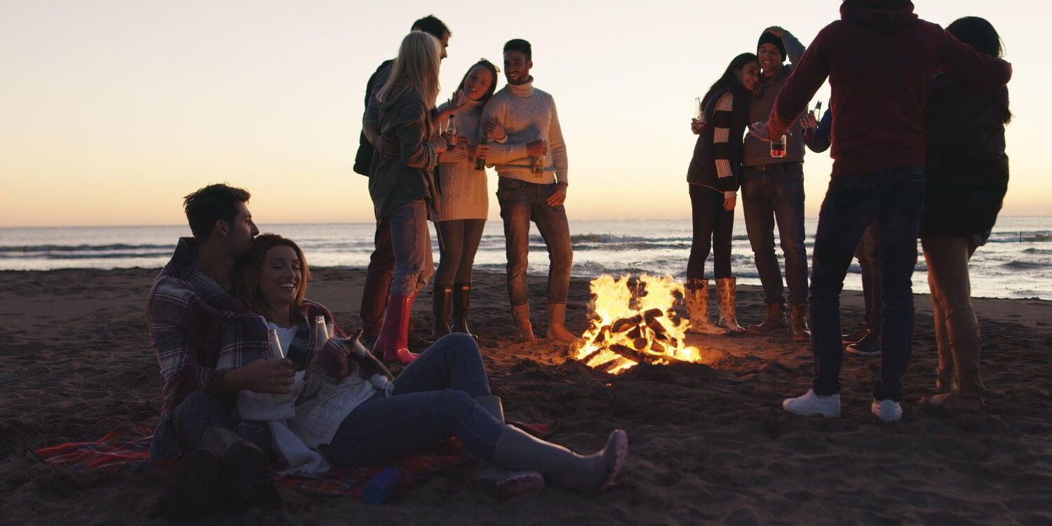 Friends enjoying beach bonfire party game