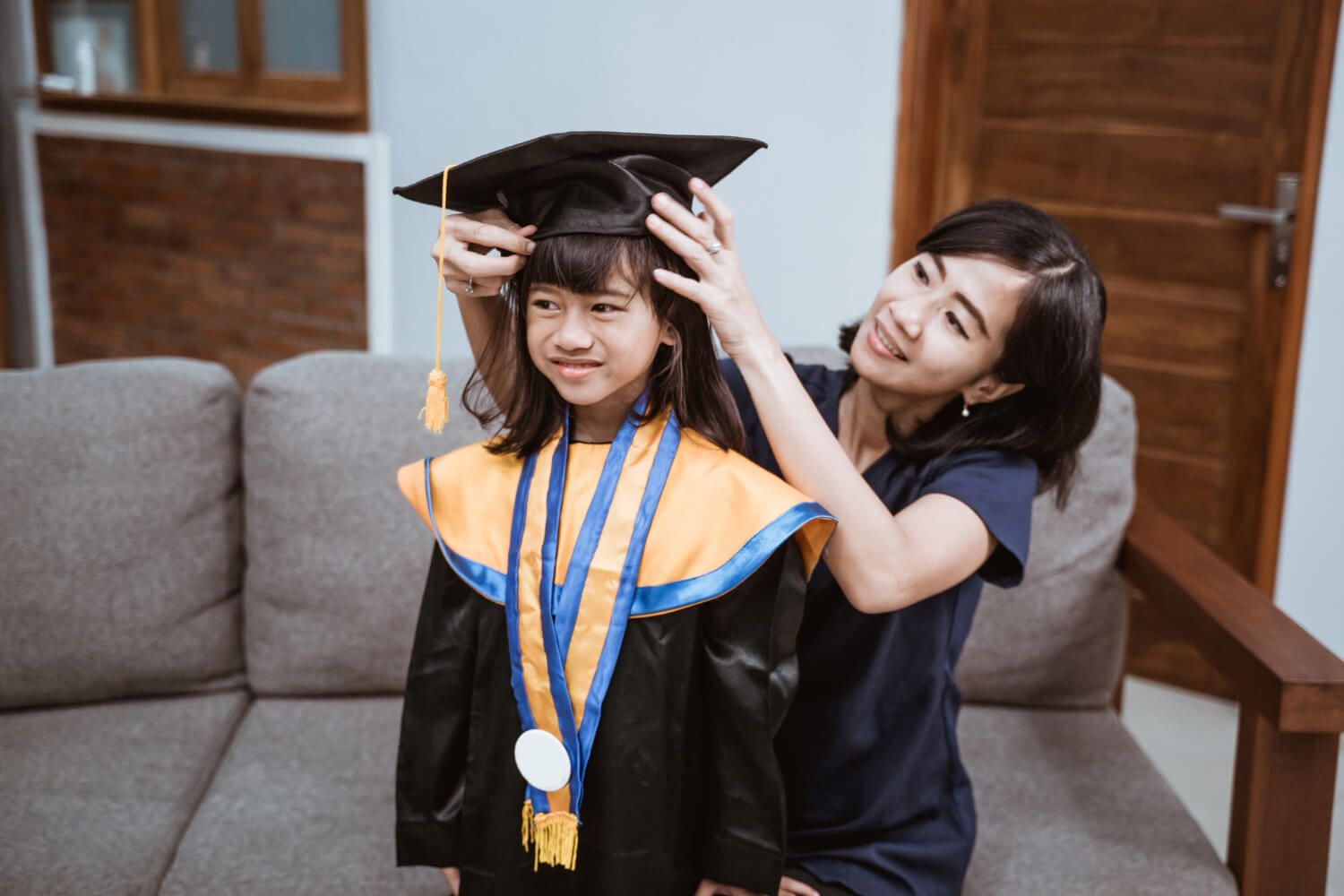 Graduate adjusting the angle of their cap in front of a mirror