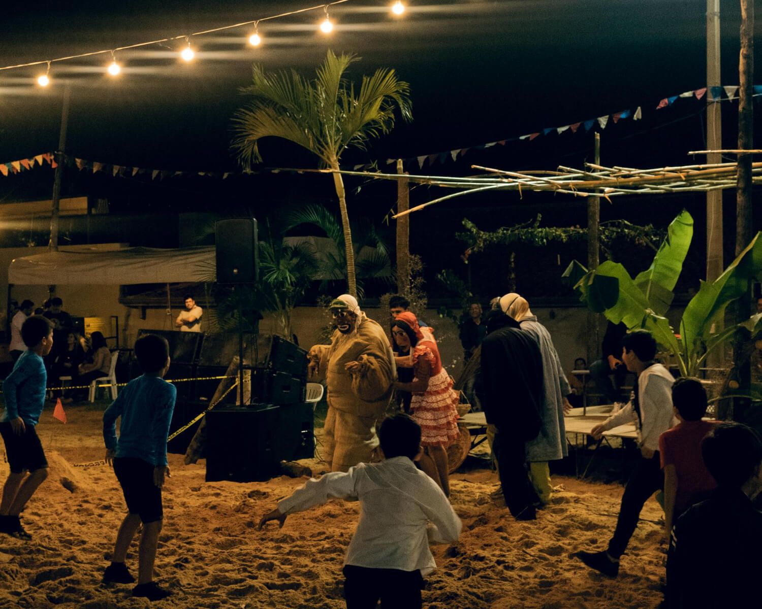 Guests playing limbo at a tropical-themed party