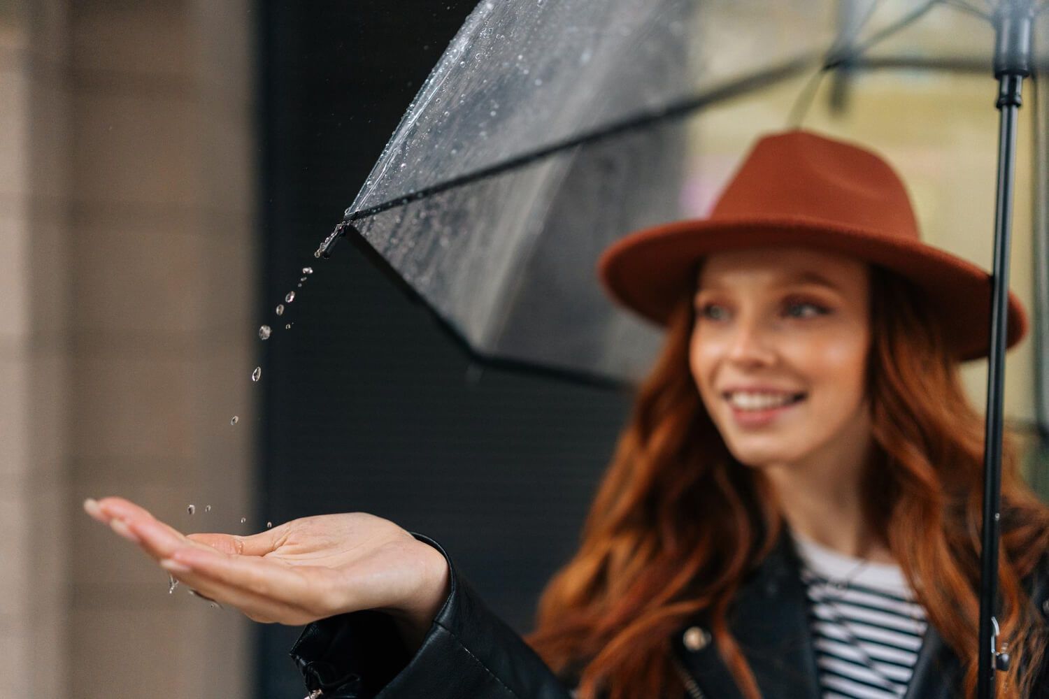 Person smiling in the rain, symbolizing reaction to life's events