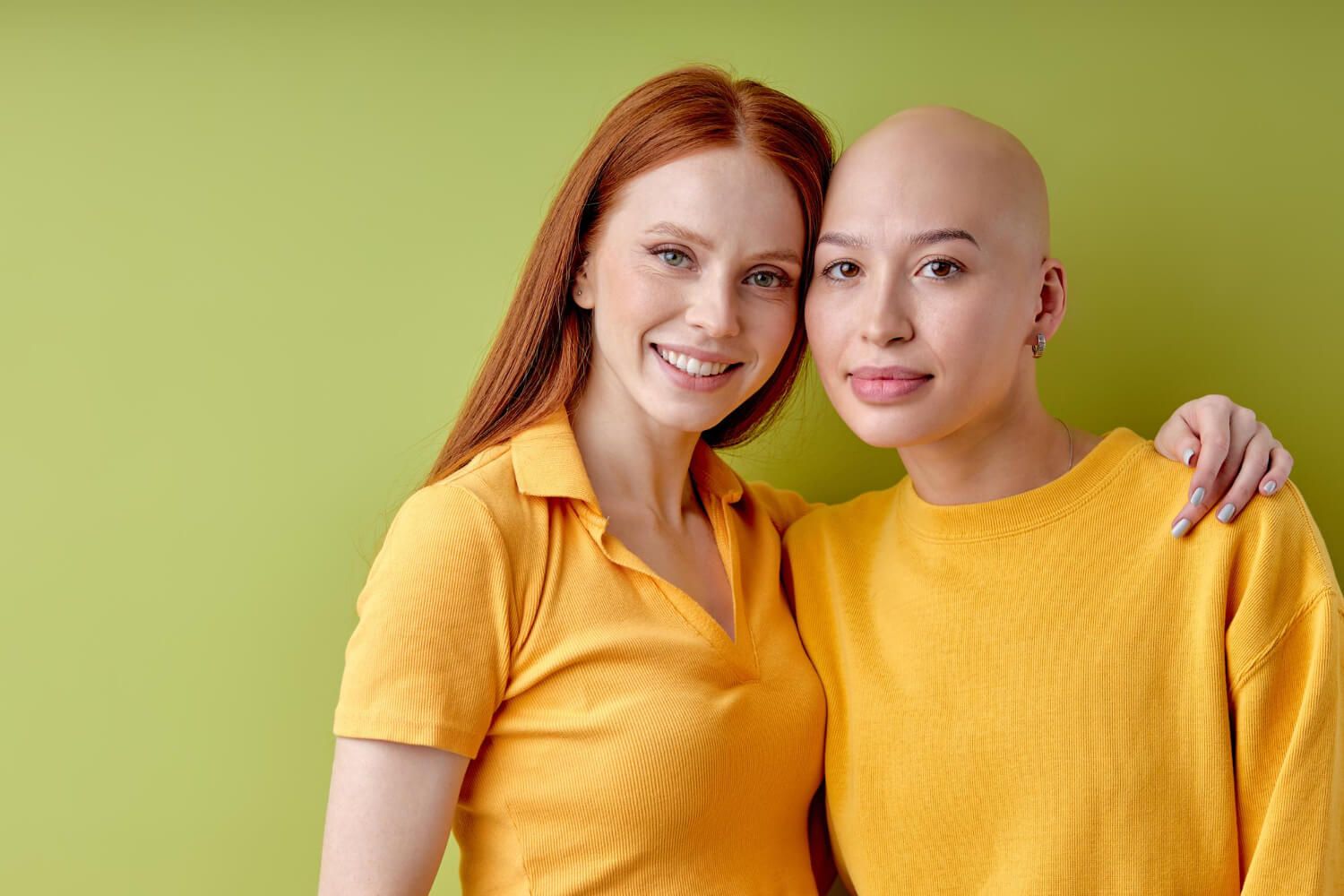 Two women sharing support, one with a bald head