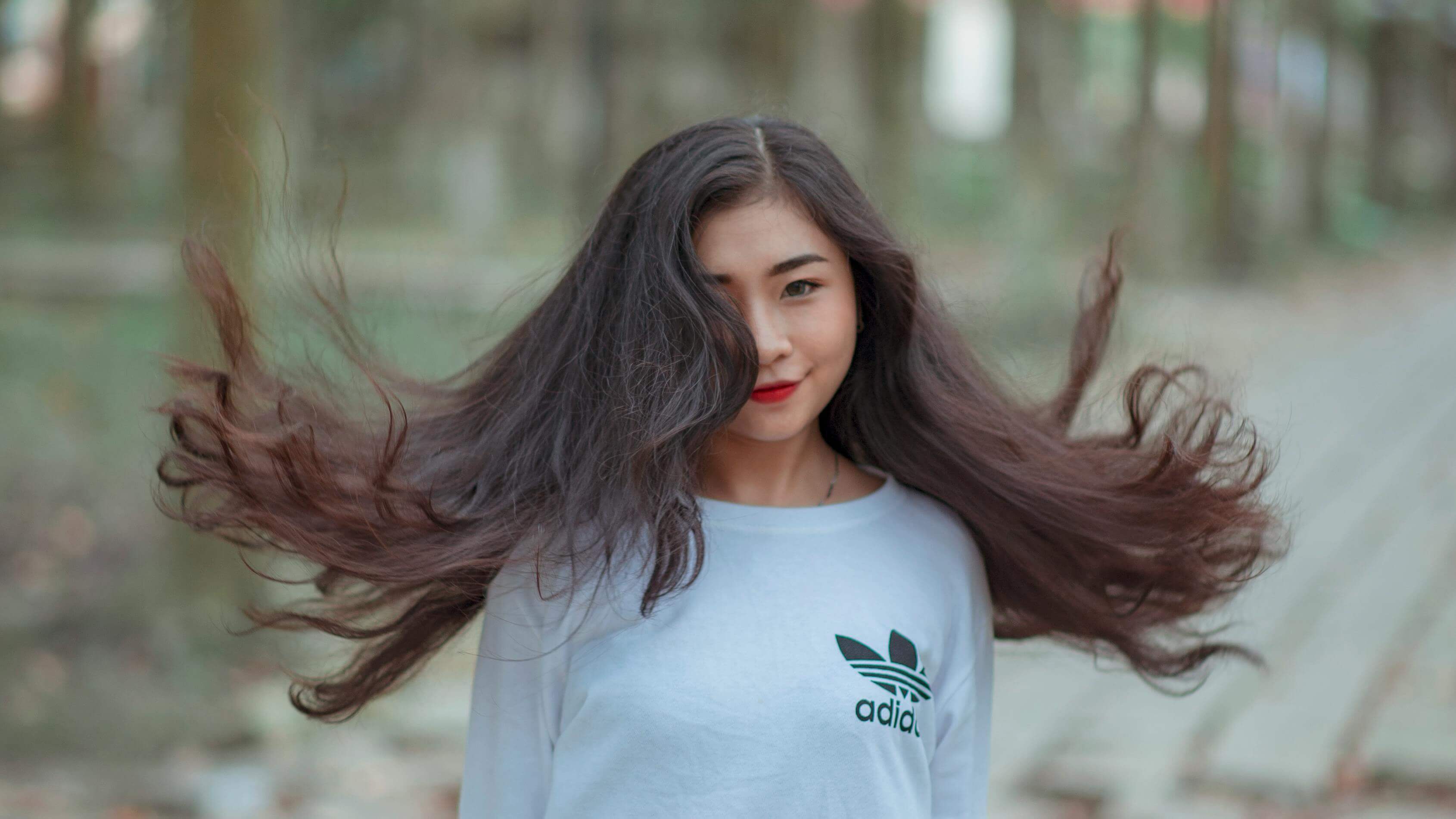 woman with hair flaired out, smizing