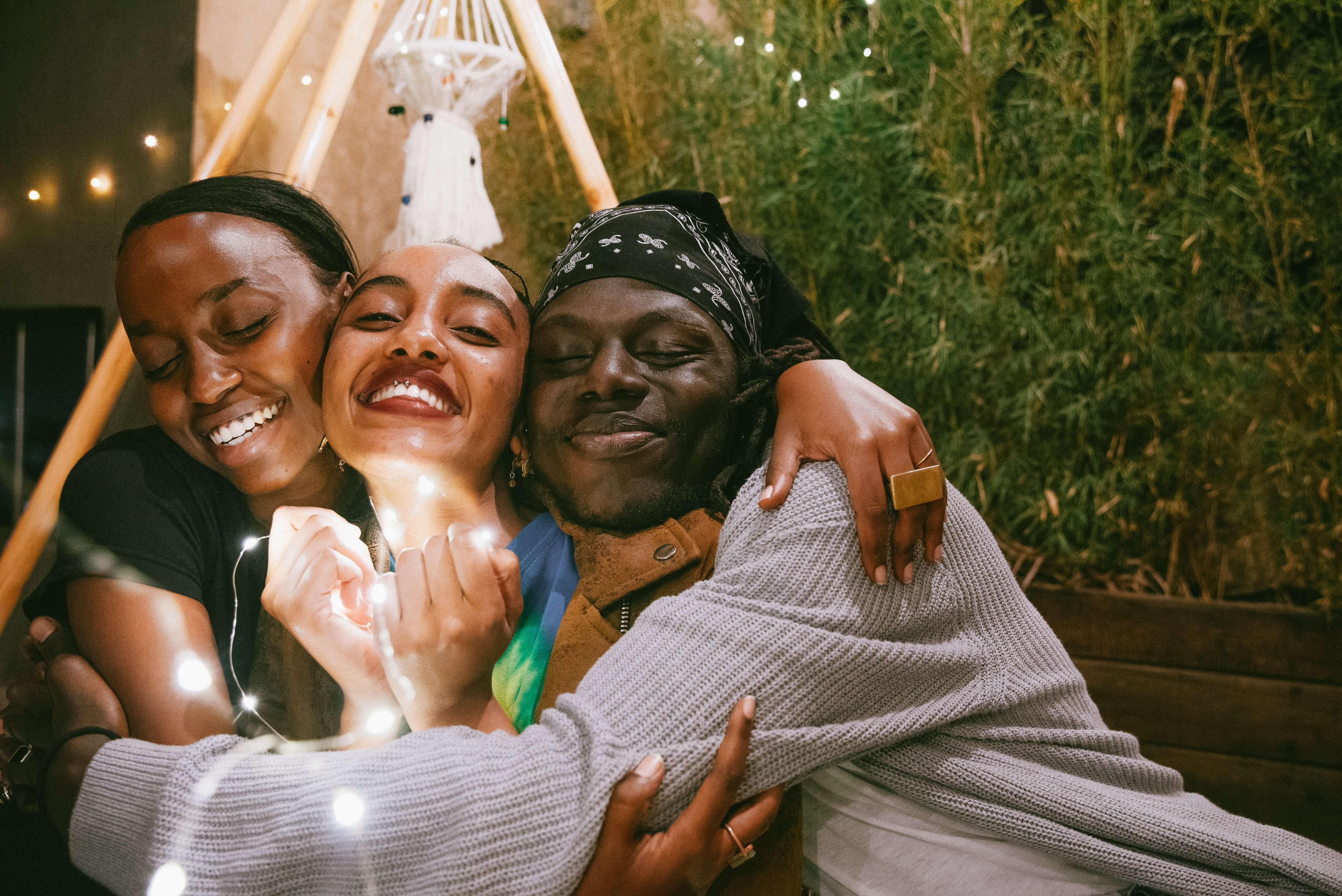 girls taking a photo in a hammock with fairy lights