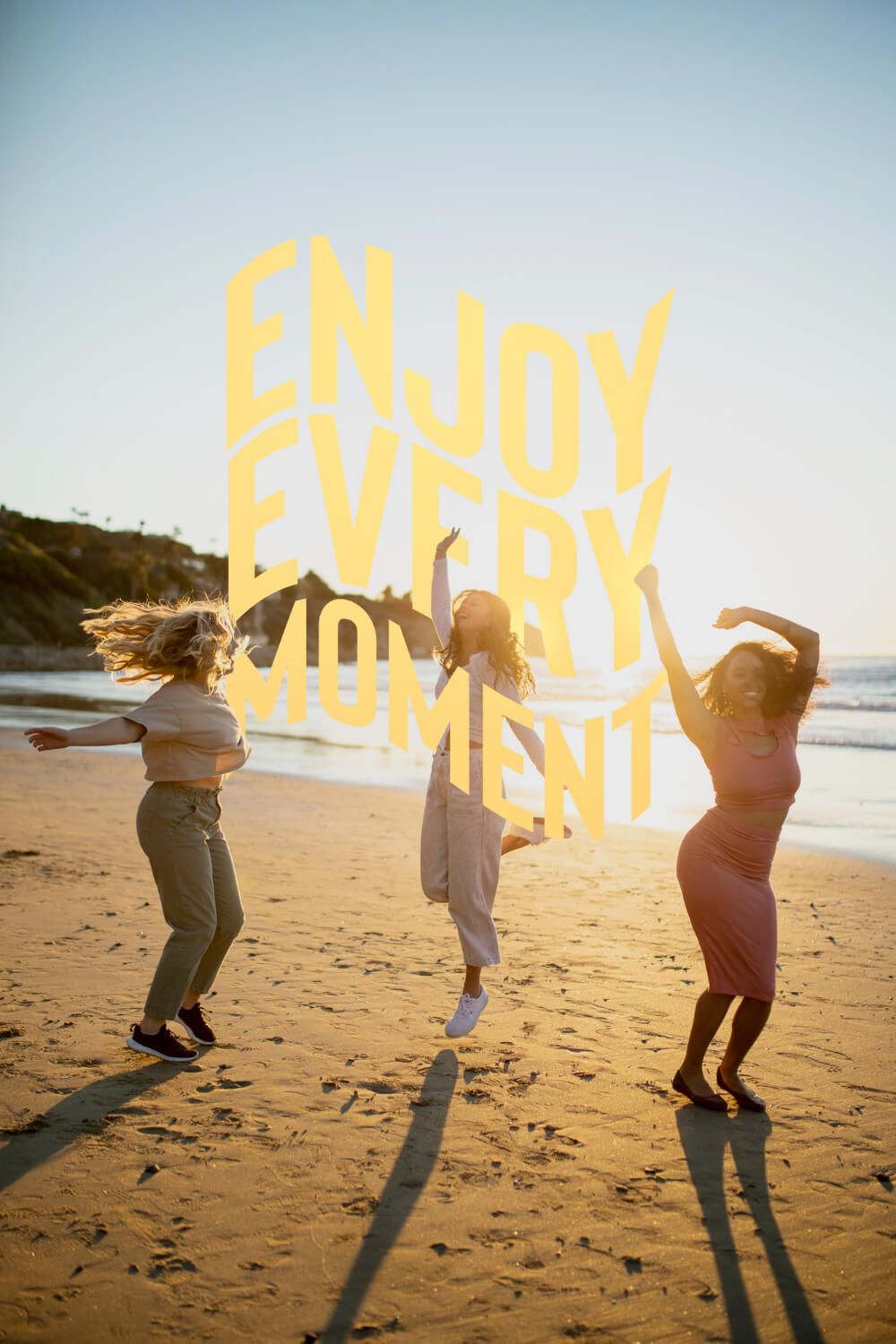 three women jumping on the sand by the sea and enjoying every moment.