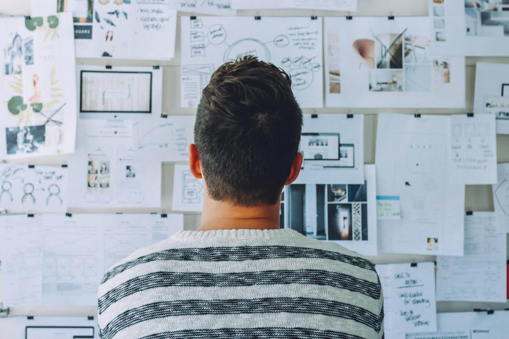 man looking at logos on wall