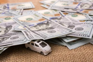 Model car covered by $100 US bills signifying auto warranty prices
