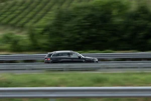 A large SUV with the best suv warranty coverage driving down the highway in a pan action shot