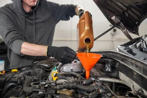Man performing routine maintenance on his car with a car warranty