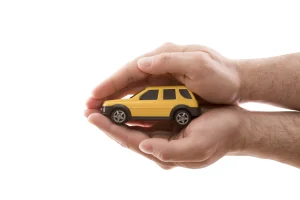 yellow toy car being cupped by two hands
