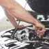 Close up hands of a mechanic doing maintenance on a car with an affordable car service contract