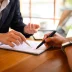 insurance agent pointing at contract showing client where to signature sign