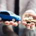 closeup of hands holding a blue toy car and gold coins