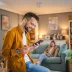 Man buying a direct-to-consumer auto warranty on his phone with his spouse looking on