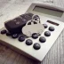 Keyring in the shape of a car on top of a calculator representing an extended warranty estimate