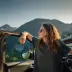 Young woman traveling by car in the mountains, summer vacation and adventure