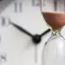 Clock and hourglass representing an extended warranty waiting period