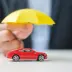 tiny yellow umbrella over a red toy car