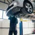 Car with a power train warranty on a lift in a garage being inspected by a mechanic